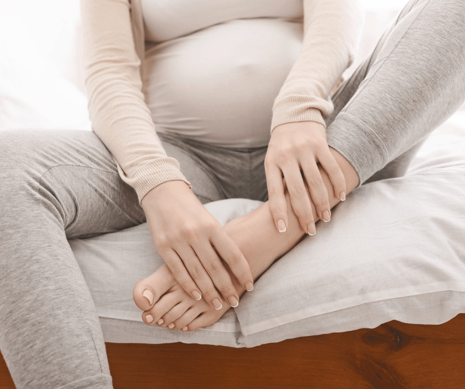 pregnant woman holding foot